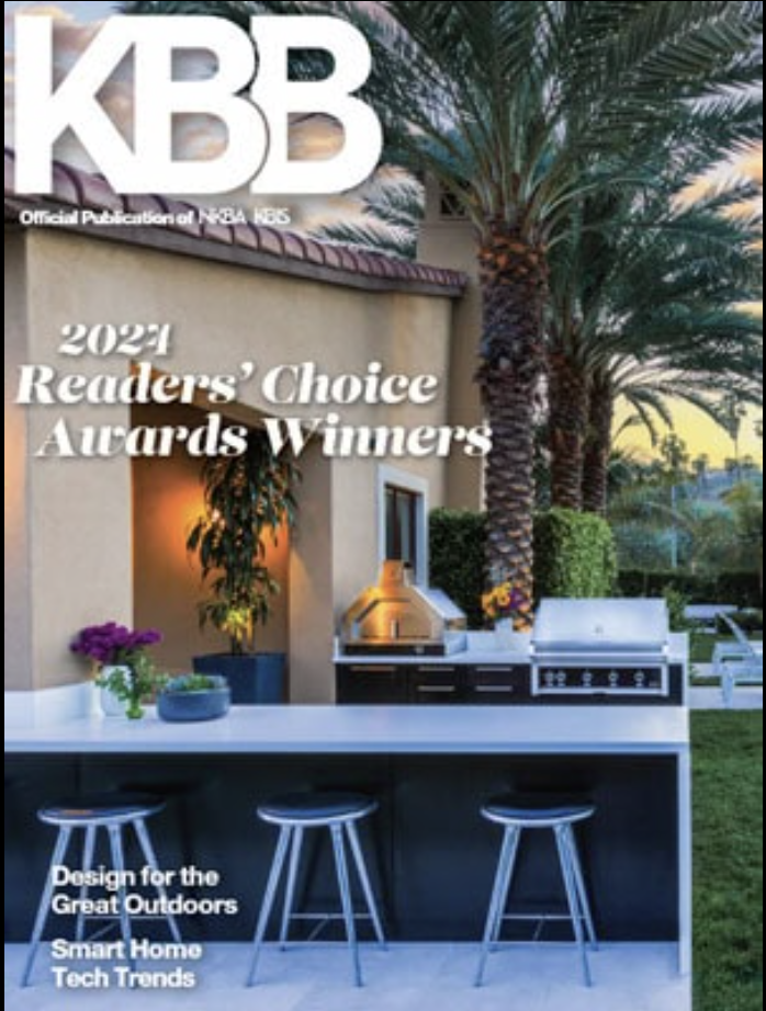 Outdoor kitchen with barstools and a grill under palm trees at sunset, designed by a top Interior Designer Massachusetts, featured on the cover of KBB magazine's 2021 Readers' Choice Awards issue.
