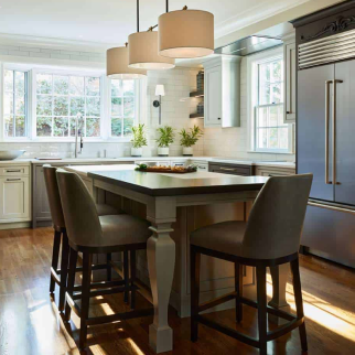 A modern kitchen with a central island, four chairs, stainless steel appliances, and large windows showcases luxury interior design, as natural light beautifully illuminates the space.