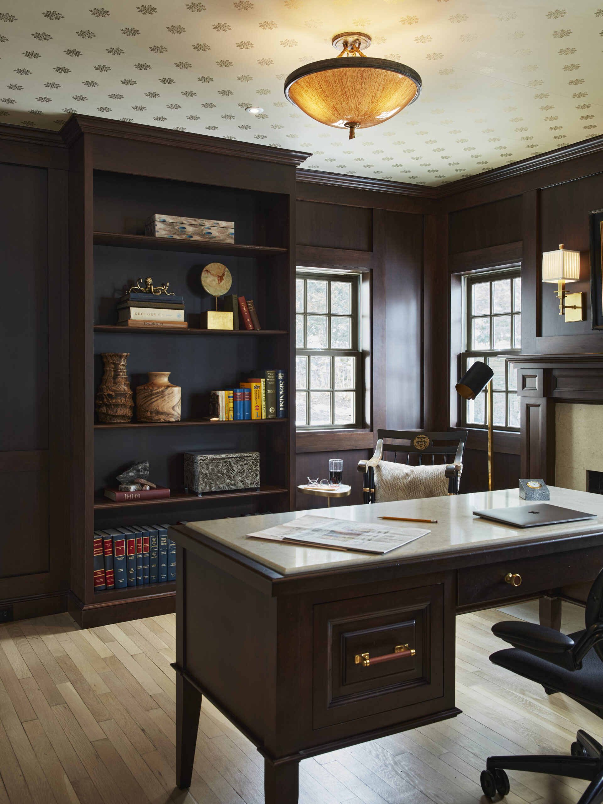 A traditional home office with dark wood furniture, built-in bookshelves, a large desk, and elegant touches inspired by luxury interior design—perfect for those seeking the expertise of an interior designer in Massachusetts.