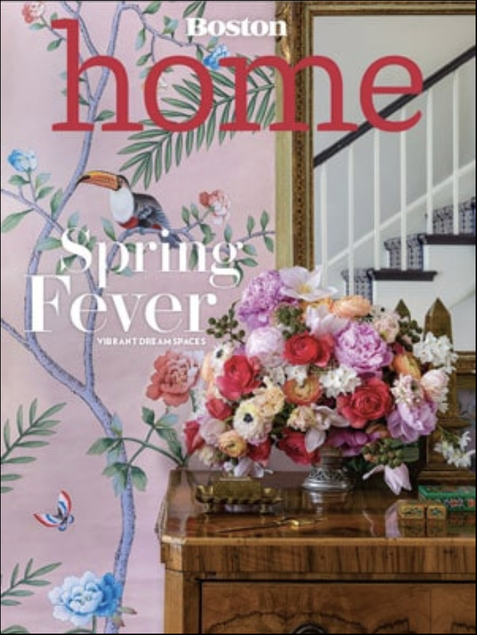 Cover of Boston Home magazine featuring a floral arrangement on a table, a mirror, a staircase, and tropical wallpaper with a toucan and flowers—showcasing luxury interior design. Text reads: 