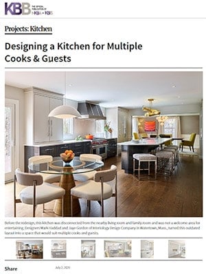 Modern kitchen with white cabinets, large island, round dining table with gray chairs, and pendant lights—a perfect example of luxury interior design by an interior designer Massachusetts homeowners trust.