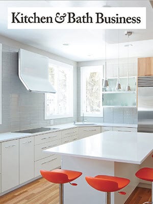 Modern kitchen with white cabinets, a large white island, three orange bar stools, pendant lights, and stainless steel appliances—showcasing Luxury Interior Design. 